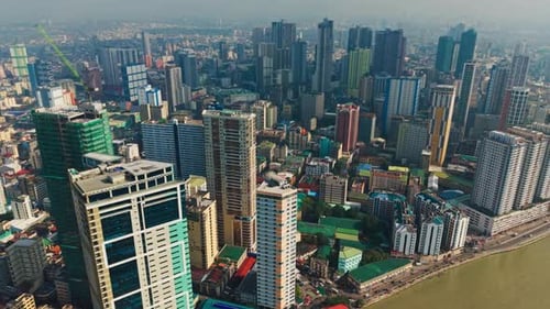 Cinematic aerial tilt up reveals Binondo skyline and Pasig River in Manila