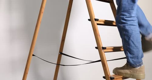 Person Climbing Wooden Ladder Indoors