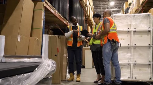 Warehouse Manager and Workers Talking in Aisle Africanamerican Ethnicity