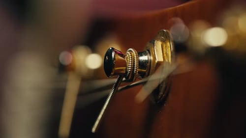 Young Musican Man Checking Strings of Acoustic Guitar Closeup Male Guitarist Tuning Sound of Musical