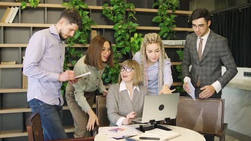 Professionals Collaborating on Laptop in Modern Office