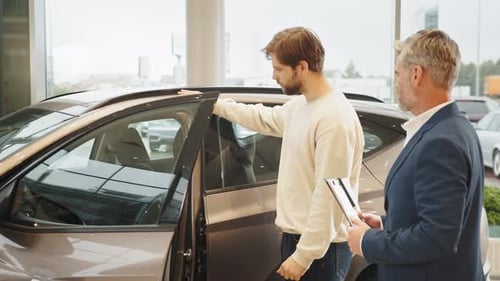 Car Agent and Customer in Car Showroom Man Choosing New Car in Salon Car Dealer
