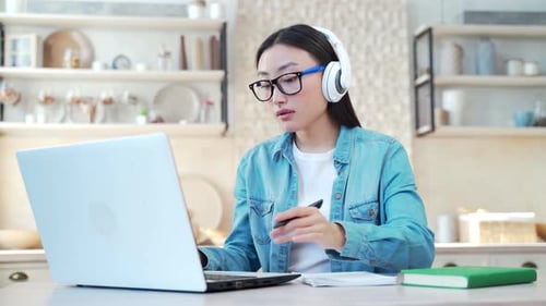 Woman Working on Laptop in Kitchen