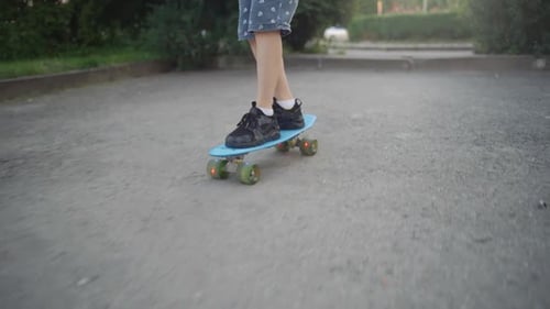 A boy learns to skate in a park in the summer