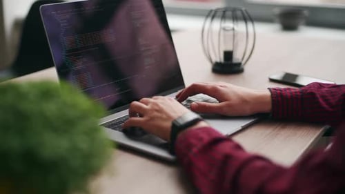 Nahaufnahme von Freelancers Händen, die Code auf der Laptop-Tastatur eingeben, rutscht um die des Entwicklers