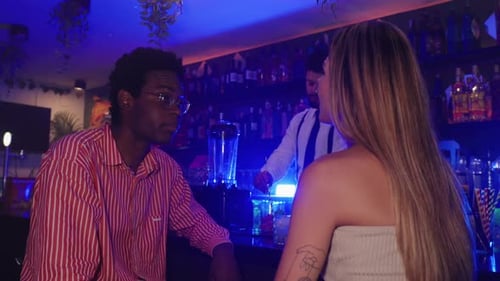 Couple Talking at Bar Counter with Bartender Preparing Cocktails in Slow Motion