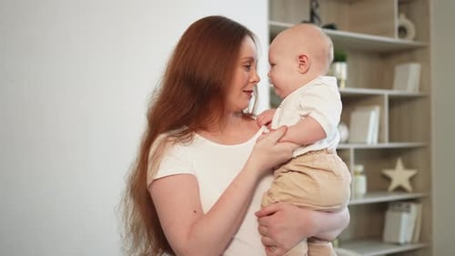 Mother and Baby Smiling and Kissing Indoors