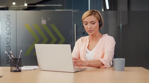 Young Woman Wearing a Headset Working in Call Center Talking to Customers