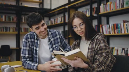 Two Friends Share a Moment Reading a Book in a Cozy Library Setting During an Afternoon Study