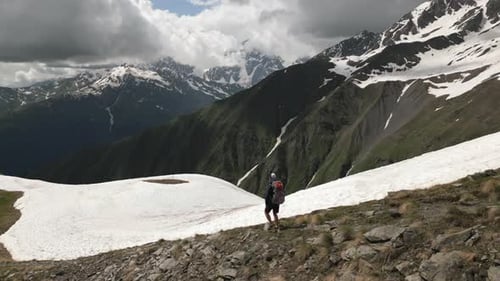 Aerial View of Solo Hiker Man with Backpack Walking in High Mountains Dramatic Scenery with