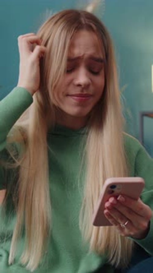 Young Woman Reacts Negatively to Message on Phone