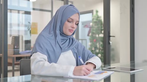 Woman in Hijab Working on Business Report in Office