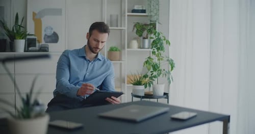 Man Working on Tablet at Desk at Home