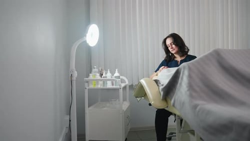 Therapist Applies Nourishing Cream to Relaxed Client Under Ring Light in Spa