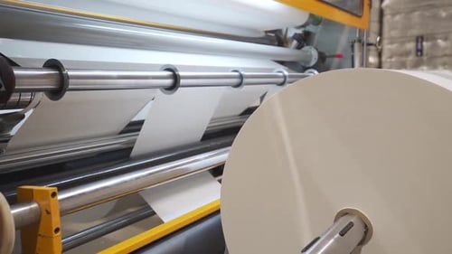 Rohstoffrolle in einer Rollenschneidemaschine in einer Druckerei. Nahaufnahme