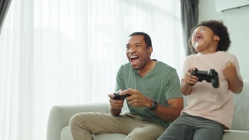 Dad and Son Play Video Games in Living Room