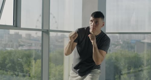 Athletic Man Shadow Boxing in Bright Studio