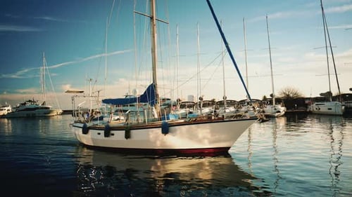 Cannes, France - December 22, 2025: A white sailboat resting in a marina basin, surrounded by rows o