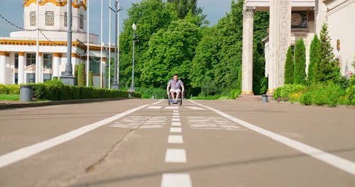 Man in Wheelchair Moves Through Urban Park