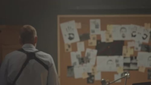 Detective Reviews Evidence on Corkboard Investigation