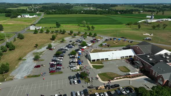 People enjoy outdoor cookout picnic. Church building and tent outside ...