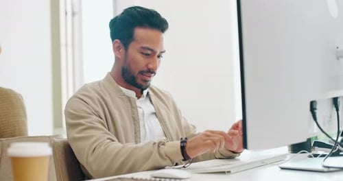 Man Typing at Computer in Modern Office