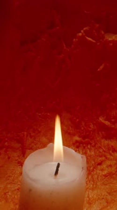 Vertical video. Background The Pumpkin Glows on Halloween Night, a Candle Burns Inside, Macro Slider