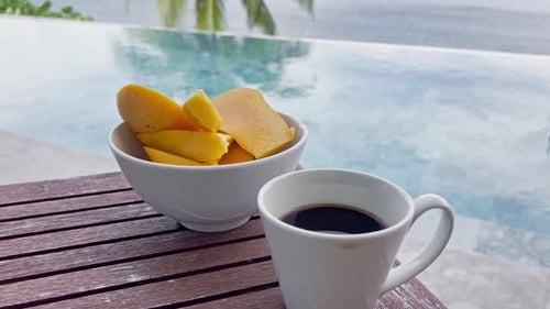 Morning Cup of Coffee and Sliced Mango on the Table By the Swimming Pool with an Incredible Sea View