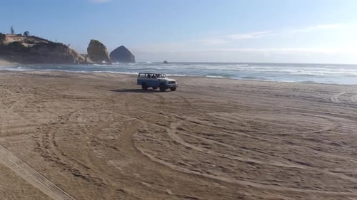 Aerial View of Group of Friends Driving on Beach in Vintage Vehicle Aerial