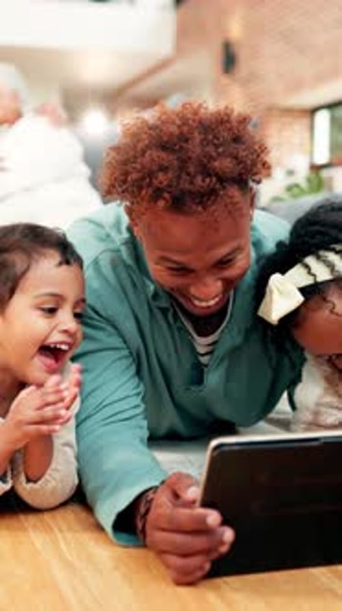 Father and Children Laughing at Tablet Indoors