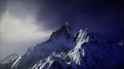 Snow Covered Mountain Peaks Under Dramatic Twilight Sky in a Remote Location