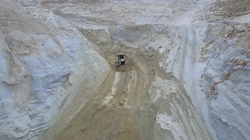 Bulldozer Moving Sand in Desert Quarry From Above