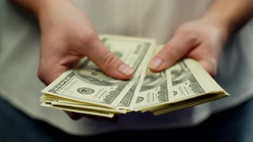 Imagen de primer plano de billetes de cien dólares dólares en manos