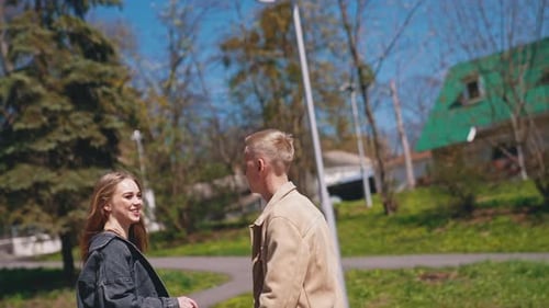 Happy couple in love holding hands of each other while spending time together in the park.