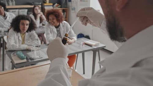 Science Teacher Demonstrates Experiment in Classroom to Students
