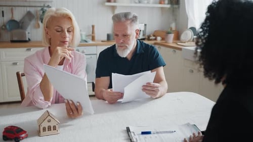 Elderly Spouses Discussing Life and Property Insurance with Woman Bank Agent Real Estate Broker