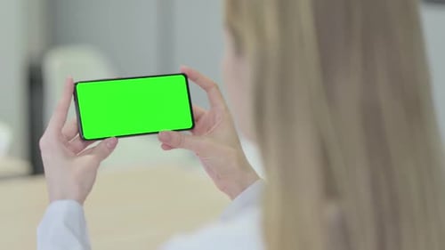 Rear View of Woman Holding Smartphone with Chroma Key