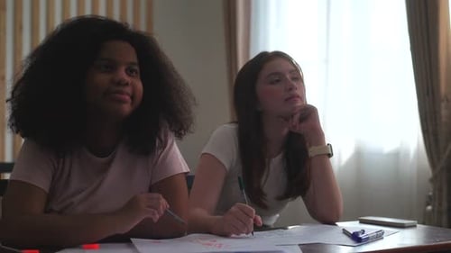 Students Drawing and Thinking at Desks in Classroom