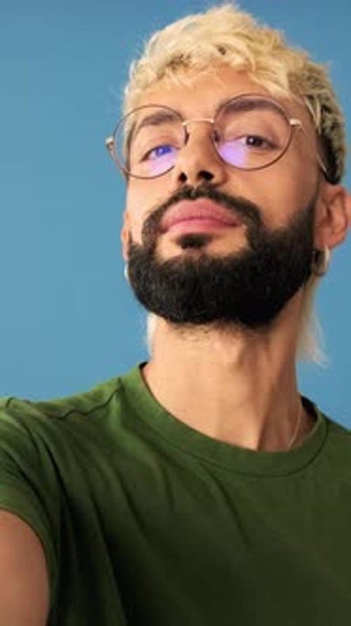 Un homme prend un selfie isolé sur fond bleu en studio