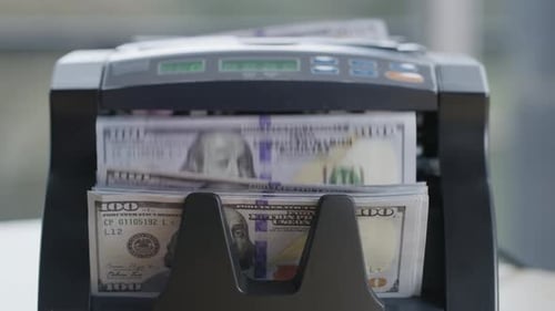 Closeup of Money Counting Machine with 100 Dollar Bills