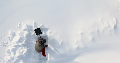 A Man Carves a Clear Path Through Thick Snow with Patience