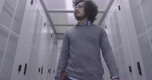 Young Adult Walking Through Server Room Data Center