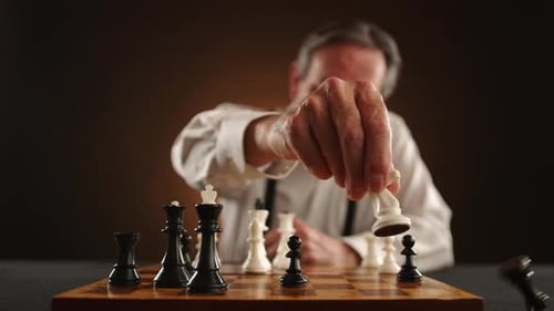Mature Adult Plays Chess on Chessboard