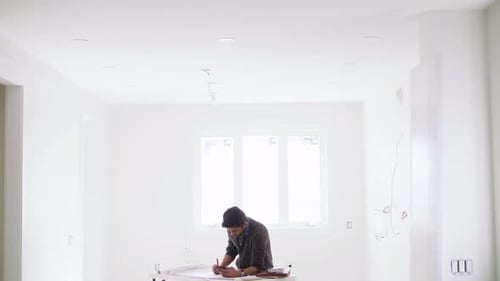 Man Reviews Plans in Bright, Empty Room