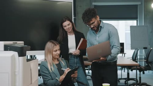 Business team collaborates on project with documents and laptops in modern office