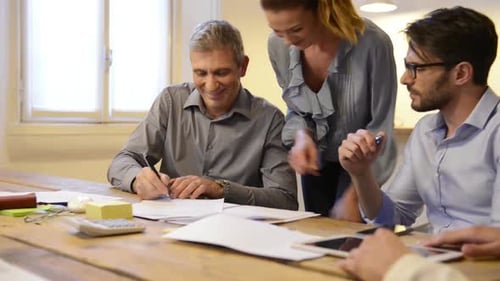 Business People Meeting Around a Table Shaking Hands