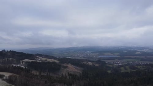 A flight over the countryside with a path leading through the trees and a view of the surrounding th