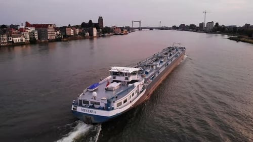Aerial drone shot of vessel Minerva sailing through the city of Dordrecht and reflection of sunlight
