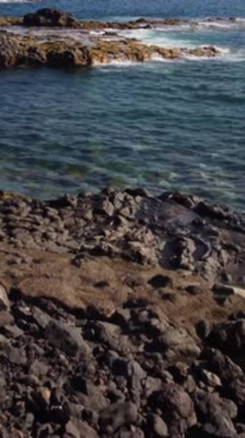 Natural Tide Pool Made Of Lava Rocks_Tenerife, Canary Island_Vertical Drone Approaching Rock Shelf
