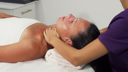 Woman Receiving Relaxing Facial Massage in Spa